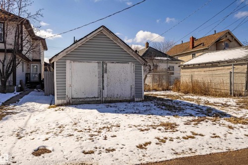 The property features a detached garage with light blue siding and a brown roof - 9328 106A Avenue, Edmonton, AB - Outdoor