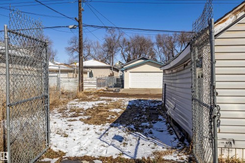 The property features a chain link fence and a detached outbuilding with siding - 9328 106A Avenue, Edmonton, AB - Outdoor