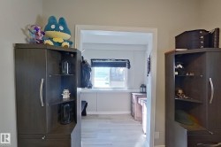 This interior space features light-toned flooring and a window with a dark roller blind, offering natural light - 
