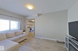 Living area featuring light-toned flooring, a window providing natural light, and a ceiling light fixture - 