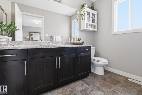 Bathroom featuring a dark wood vanity with a light-colored countertop, an undermount sink, and tiled flooring - 430 Watt Boulevard, Edmonton, AB - Indoor Photo Showing Bathroom