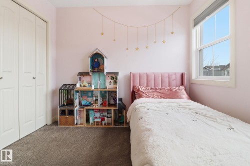 This bedroom features light pink walls, a window with a white frame, and soft carpet flooring - 430 Watt Boulevard, Edmonton, AB - Indoor Photo Showing Bedroom