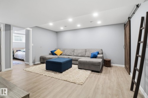 This versatile living space features light-colored flooring, recessed lighting, and a modern barn door - 430 Watt Boulevard, Edmonton, AB - Indoor Photo Showing Basement