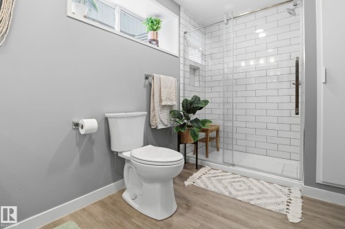 This bathroom features a white toilet, light gray walls, and wood-look flooring - 430 Watt Boulevard, Edmonton, AB - Indoor Photo Showing Bathroom
