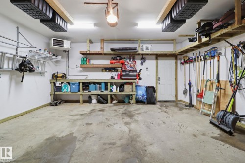 The garage features a concrete floor, overhead lighting, and built-in shelving for storage - 430 Watt Boulevard, Edmonton, AB - Indoor Photo Showing Garage
