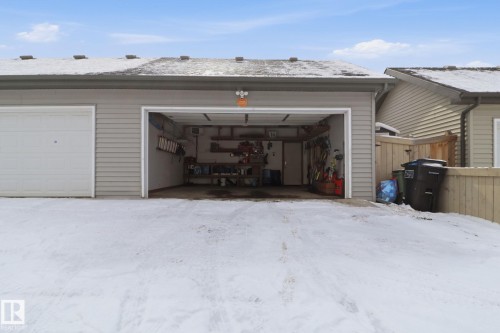 The property features an attached two-car garage with a light gray exterior and a paved driveway - 430 Watt Boulevard, Edmonton, AB - Outdoor With Exterior