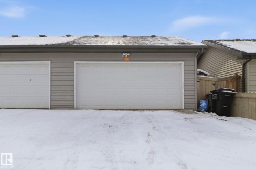 The property features a two-car garage with white sectional doors and light grey horizontal siding - 430 Watt Boulevard, Edmonton, AB - Outdoor With Exterior