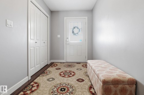 Inviting entryway featuring a white paneled door with decorative glass, a coat closet with bi-fold doors, and light gray painted walls - 430 Watt Boulevard, Edmonton, AB - Indoor