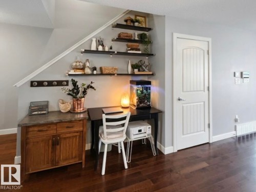 This area features rich hardwood flooring, a white paneled door, and built-in shelving - 430 Watt Boulevard, Edmonton, AB - Indoor Photo Showing Other Room