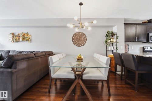 The dining area features hard wood flooring and a modern chandelier, creating a refined atmosphere - 430 Watt Boulevard, Edmonton, AB - Indoor Photo Showing Dining Room