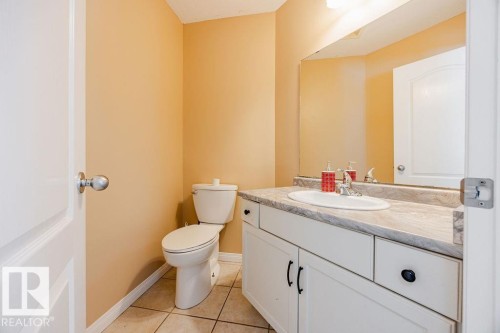 Bathroom featuring a toilet, a vanity with a countertop and an integrated sink, and a large mirror - 7 Doucette Place, St. Albert, AB - Indoor Photo Showing Bathroom