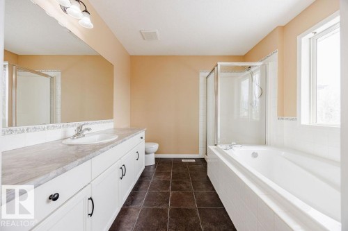 Bathroom featuring a spacious vanity with white cabinetry and a large mirror, a white tiled bathtub, and a separate shower enclosure - 7 Doucette Place, St. Albert, AB - Indoor Photo Showing Bathroom