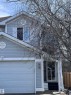 The property features light blue siding, a white garage door, and a front entry with dark steps and a storm door - 7 Doucette Place, St. Albert, AB  - Outdoor 