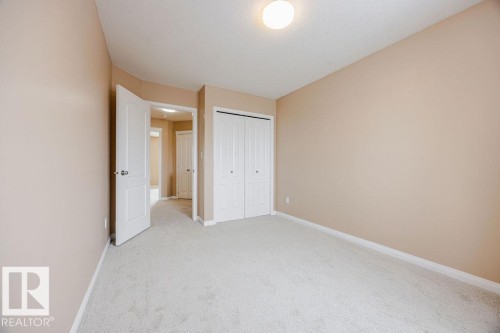 The room features neutral-toned walls, a light-colored carpet, and a ceiling-mounted light fixture - 7 Doucette Place, St. Albert, AB - Indoor Photo Showing Other Room