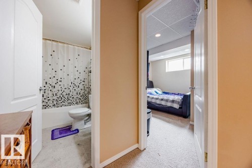 The property includes a bathroom with a white tub and toilet, and a separate room with carpeting and a window - 7 Doucette Place, St. Albert, AB - Indoor