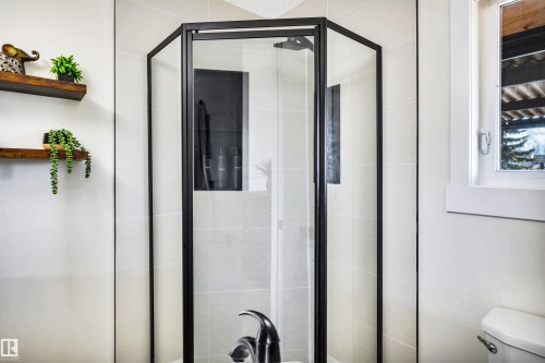 Bathroom featuring a corner shower with a black frame and clear glass enclosure - 5201 40 Avenue, Beaumont, AB - Indoor Photo Showing Bathroom