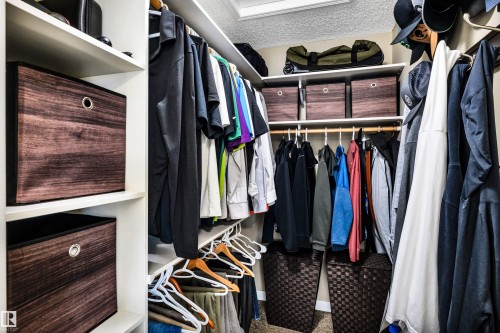 Walk-in closet featuring extensive built-in shelving and hanging rods for storage - 5201 40 Avenue, Beaumont, AB - Indoor With Storage