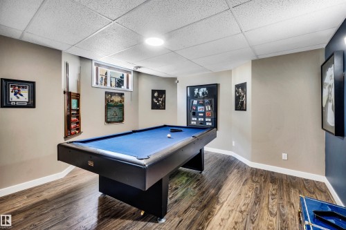 Recreation area featuring wood-style flooring, a drop ceiling with recessed lighting, and a window - 5201 40 Avenue, Beaumont, AB - Indoor Photo Showing Other Room