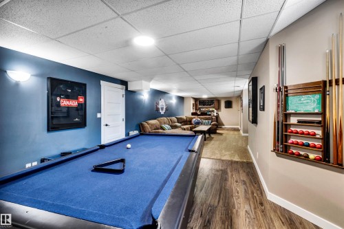 The property features a recreational room with a billiards table, wood-style flooring, and a drop ceiling with recessed lighting - 5201 40 Avenue, Beaumont, AB - Indoor Photo Showing Other Room
