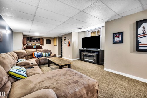 This spacious room features neutral toned walls, recessed lighting, and a window providing natural light - 5201 40 Avenue, Beaumont, AB - Indoor Photo Showing Basement