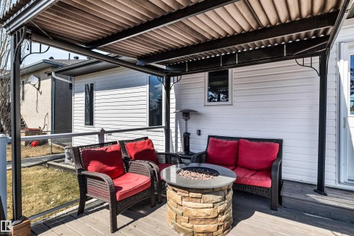 The property includes a covered patio area with a stone fire pit, offering a comfortable outdoor space - 5201 40 Avenue, Beaumont, AB - Outdoor With Deck Patio Veranda With Exterior