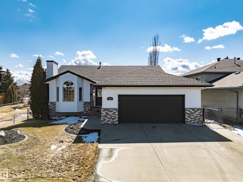 The property features a white exterior with stone accents and a dark roof - 5201 40 Avenue, Beaumont, AB - Outdoor