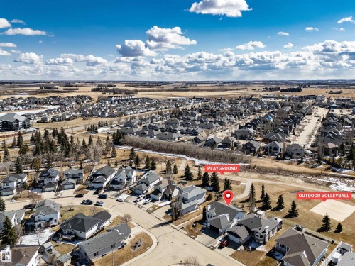 Aerial view showcasing the residential community with an outdoor volleyball court and a playground nearby - 5201 40 Avenue, Beaumont, AB - Outdoor With View