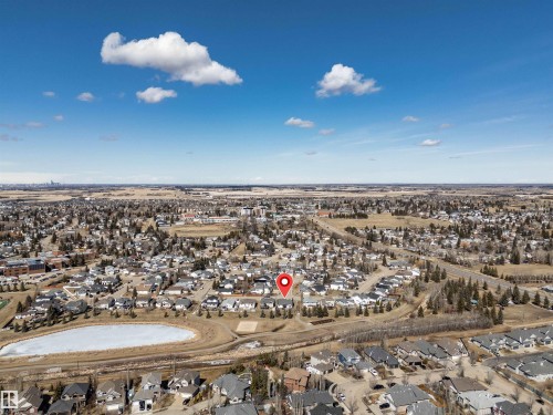 Property located within a developed residential area, featuring a pond with a partially frozen surface - 5201 40 Avenue, Beaumont, AB - Outdoor With View