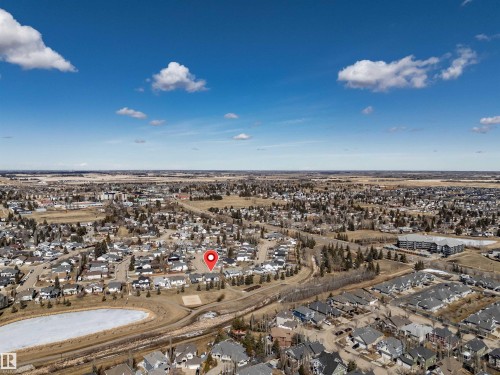 Aerial view of the community, showcasing residential properties, a nearby body of water, and surrounding open landscape under a clear sky - 5201 40 Avenue, Beaumont, AB - Outdoor With View
