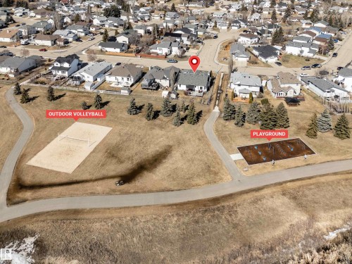 Aerial view showcasing the property's proximity to recreational amenities, including an outdoor volleyball court and a playground - 5201 40 Avenue, Beaumont, AB - Outdoor With View
