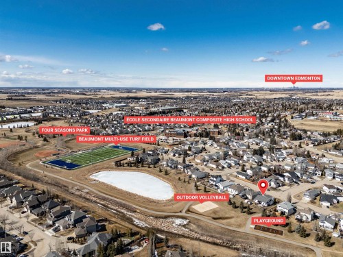 Aerial view showcasing the property's location within a developed community, featuring nearby recreational amenities such as a multi-use turf field, a park, and an outdoor volleyball court - 5201 40 Avenue, Beaumont, AB - Outdoor With View