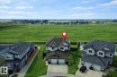 The property features a two-story design with an attached two-car garage, a paved driveway, and a well-maintained lawn - 130 Kirpatrick Way, Leduc, AB  - Outdoor With View 