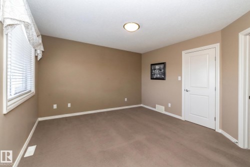 This room features neutral-toned walls, a white ceiling, and plush carpeting, creating a versatile aesthetic - 130 Kirpatrick Way, Leduc, AB - Indoor Photo Showing Other Room