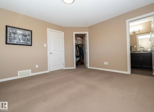 This room features neutral-toned carpet flooring, light beige wall paint, and white trim - 130 Kirpatrick Way, Leduc, AB - Indoor Photo Showing Other Room