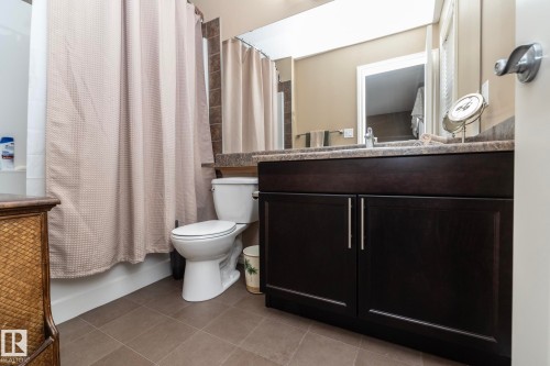 Bathroom featuring a dark wood vanity with a light-colored countertop, a white toilet, and tile flooring - 130 Kirpatrick Way, Leduc, AB - Indoor Photo Showing Bathroom