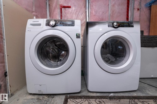The property includes a laundry area featuring a front-loading washer and a front-loading dryer - 130 Kirpatrick Way, Leduc, AB - Indoor Photo Showing Laundry Room