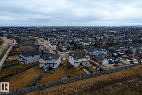 Aerial view of the surrounding neighborhood showcasing properties with sloped roofs and backyards - 130 Kirpatrick Way, Leduc, AB - Outdoor With View
