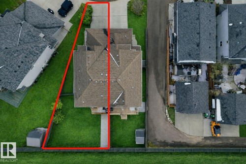 Aerial view of the property showcasing the exterior, driveway, and surrounding green space - 130 Kirpatrick Way, Leduc, AB - 