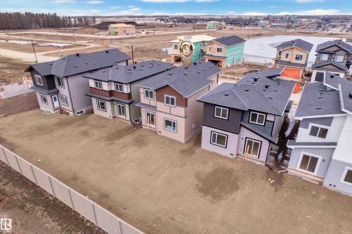 This property features a two-story design with a dark gray shingle roof and a light-colored exterior with dark accents - 237 Linden Loop, Leduc, AB - Outdoor