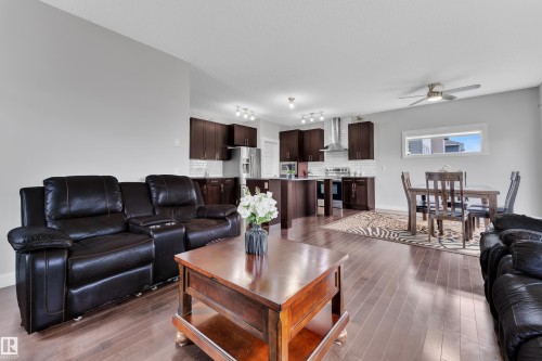 Living area featuring hardwood floors and an open concept layout with views of the kitchen and dining area - 1452 30 Street, Edmonton, AB - Indoor Photo Showing Living Room