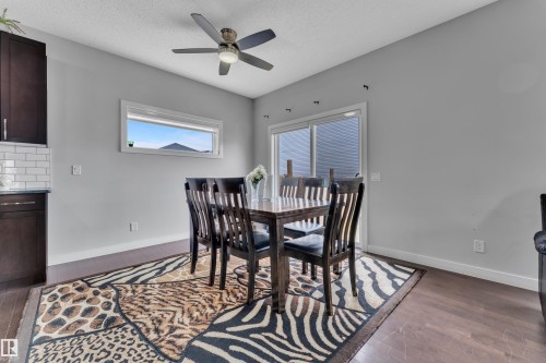 Dining area featuring hardwood floors, a ceiling fan, a window, and sliding glass doors - 1452 30 Street, Edmonton, AB - Indoor Photo Showing Dining Room