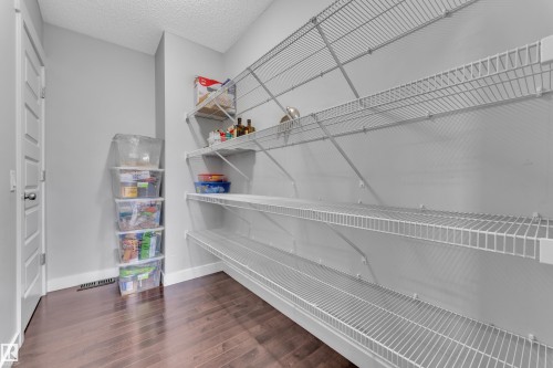 The property features a pantry with dark hardwood floors and extensive wire shelving for storage - 1452 30 Street, Edmonton, AB - Indoor With Storage