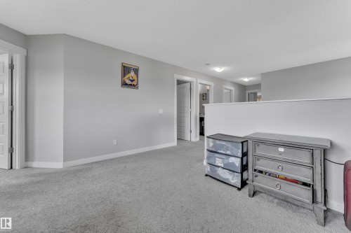 This interior space features light grey walls and light grey carpeting, providing a neutral aesthetic - 1452 30 Street, Edmonton, AB - Indoor
