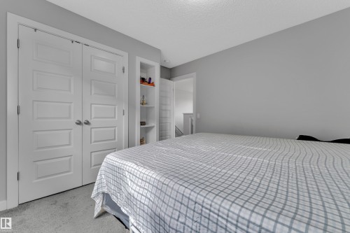 This room features neutral gray wall paint, recessed shelving, and paneled closet doors - 1452 30 Street, Edmonton, AB - Indoor Photo Showing Bedroom