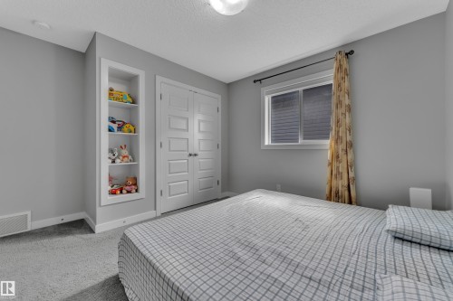 This room features soft gray wall paint, light gray carpeting, and a window with blinds and a curtain rod - 1452 30 Street, Edmonton, AB - Indoor Photo Showing Bedroom
