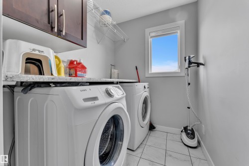Utility area featuring a window, built-in cabinetry, and tile flooring - 1452 30 Street, Edmonton, AB - Indoor Photo Showing Laundry Room