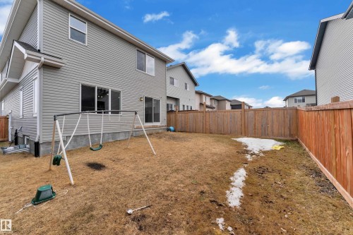 The property features a private backyard with a wooden fence and a swing set - 1452 30 Street, Edmonton, AB - Outdoor With Exterior