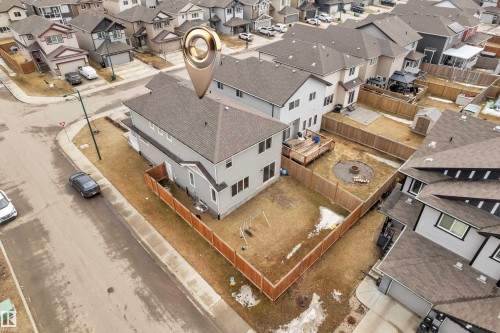 The property features a fenced yard with a deck and a fire pit area, alongside a swing set and a shed - 1452 30 Street, Edmonton, AB - 