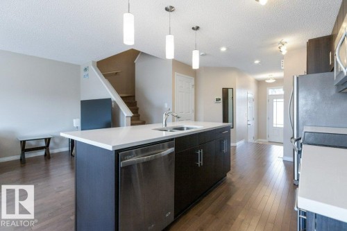 The property features an open-concept layout with hardwood floors throughout the main living areas - 3119 Carpenter Landing Landing, Edmonton, AB - Indoor Photo Showing Kitchen With Double Sink