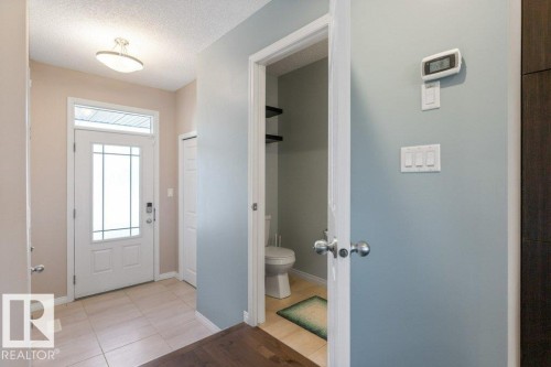 Entryway with tile flooring, a white front door with decorative glass, and a flush mount ceiling light fixture - 3119 Carpenter Landing Landing, Edmonton, AB - Indoor